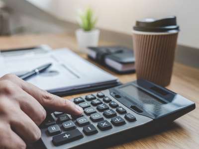 Businessman working on a graph document financial report and analysis calculation investment cost